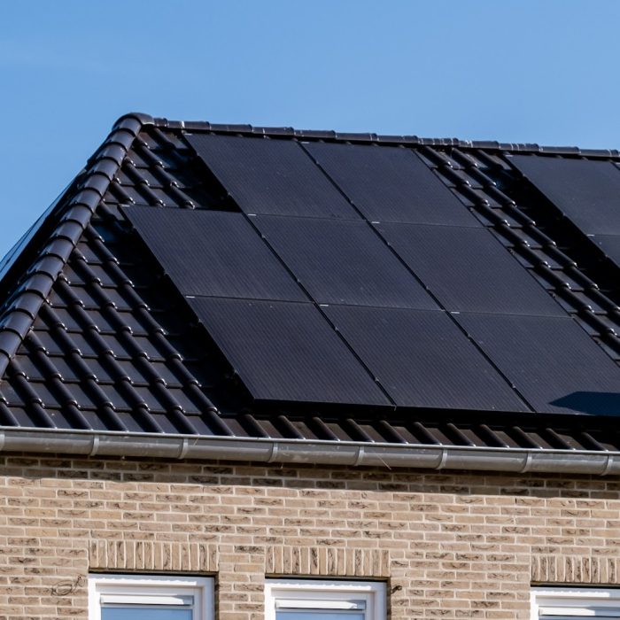 Newly build houses with black solar panels attached to the roof